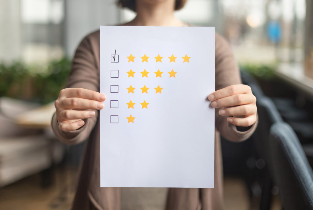Woman choosing with tick five star rating on paper sheet